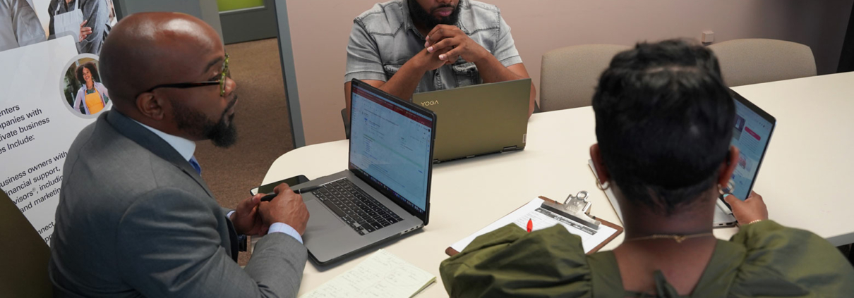 A mentor at a business incubator helping a small business owner draft an early-stage business model.